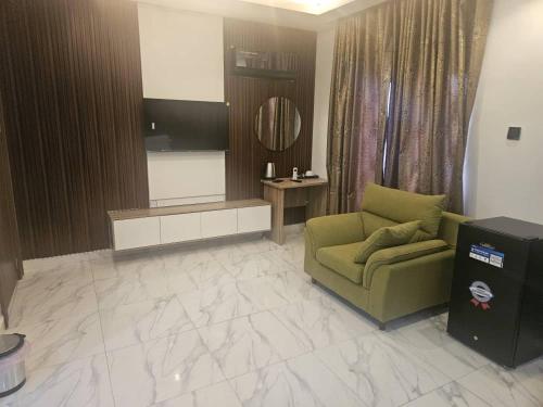 a living room with a green couch and a television at Soilsmart Haven in Abuja