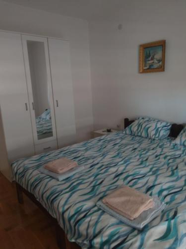 a bedroom with a bed with two towels on it at La Hacienda DD in Trebinje