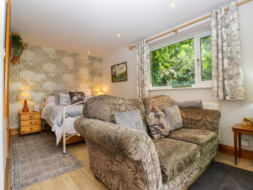 a living room with a couch and a bed at La'al Yan in Workington