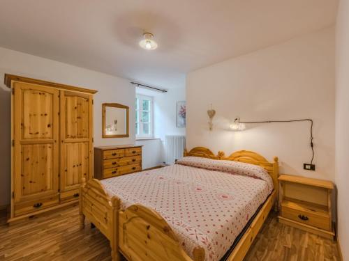 a bedroom with a wooden bed and a dresser at Apartment Betulla by Interhome in Rabbi