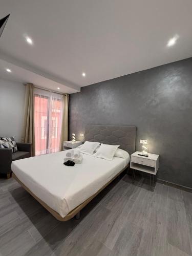 a bedroom with a large white bed and two tables at Casa Azul in Villajoyosa