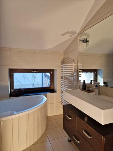 a bathroom with a large tub and a sink at InOut Dom Olsztyn in Olsztyn