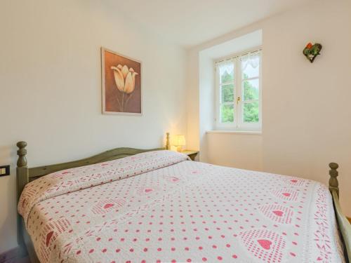 a bedroom with a bed with a bedspread and a window at Apartment Abete by Interhome in Rabbi