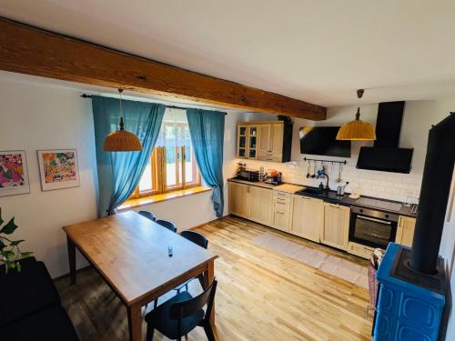 a kitchen with a wooden table and a dining room at Škorničkův statek - chalupa Andělka s wellness za příplatek in Hamr