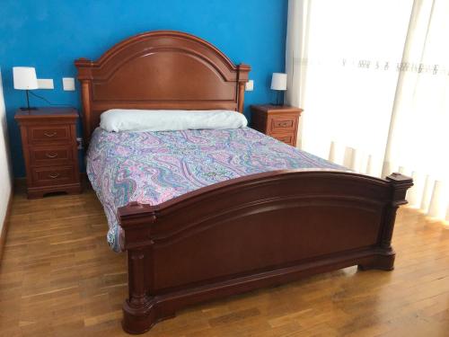 a bedroom with a wooden bed and two night stands at Villaviciosa in Villaviciosa