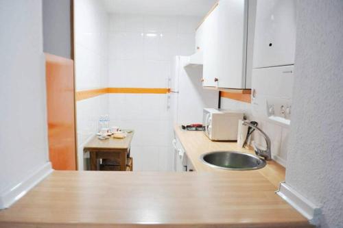 a small kitchen with a sink and a microwave at Villaviciosa in Villaviciosa
