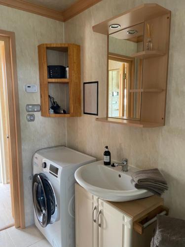 a bathroom with a washing machine and a sink at Het Kempens huisje in Lille