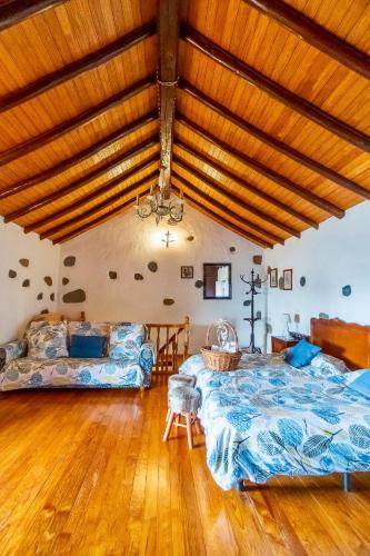 a bedroom with a large bed and a couch at Casa Rural Guiniguada in Santa Brígida