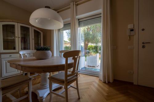 a dining room with a table and a large window at ReDavid House Villa in Torre a Mare