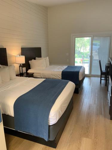a hotel room with two beds and a balcony at Lodge at Chalk Hill in Uniontown