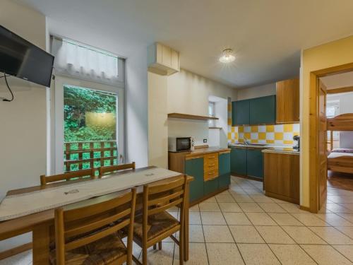 a kitchen with green cabinets and a table with chairs at Apartment Abete e Betulla by Interhome in Rabbi