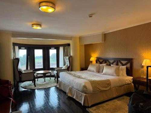 a hotel room with a bed and a desk and chairs at The Treetops Lodge in Nyeri