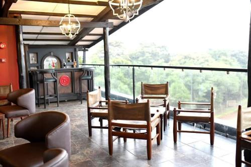a room with chairs and a table and a bar at The Treetops Lodge in Nyeri