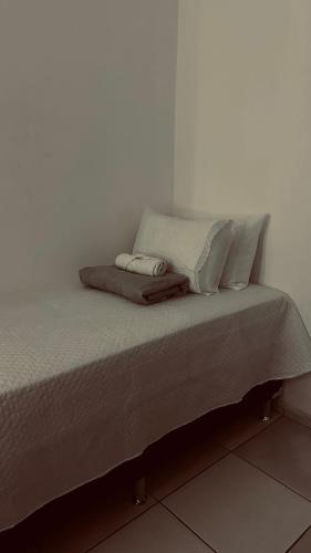 a bed with two towels on top of it at Quarto privativo com penteadeira LED - n 326A in Petrolina