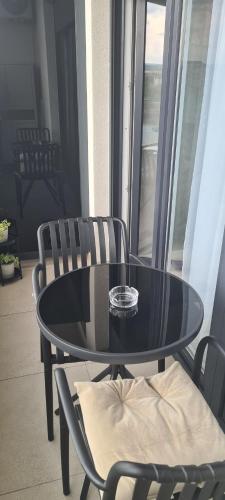 a black table and chairs in a room with a window at Apartman Filip in Paraćin