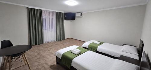 a hotel room with two beds and a table at Archa hotel in Osh