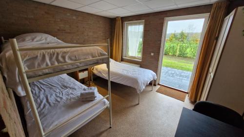 ein Zimmer mit zwei Etagenbetten und einem Fenster in der Unterkunft Campingkamer in Knegsel