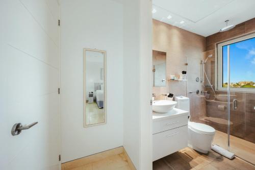 a bathroom with a toilet and a sink and a shower at 2 BR Oceanview Condo Coral Shell 3e in Oranjestad