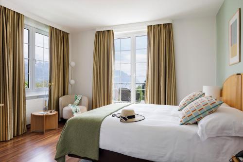 a bedroom with a bed with a hat on it at Hotel du Léman - Jongny in Vevey