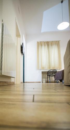 an empty room with a wooden floor and a couch at Trapani Home in Trapani