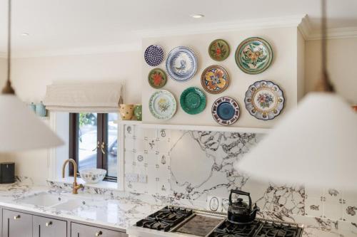 a kitchen with plates on the wall above a stove at Sandown, Spacious and Stylish in Southwold in Southwold