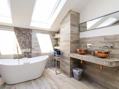 a bathroom with a tub and a sink and a bath tub at Ty Haul in Rhosneigr