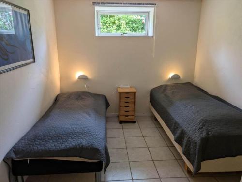 two beds in a small room with a window at FJ1603-Jaegerspris-Kystsvinget-3 in Jægerspris