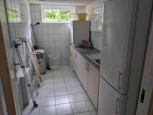 a small kitchen with a sink and a refrigerator at FJ1603-Jaegerspris-Kystsvinget-3 in Jægerspris