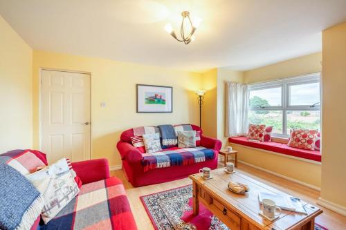 a living room with two red couches and a table at 2 Bed in Bamburgh oc-nb282 in Bamburgh
