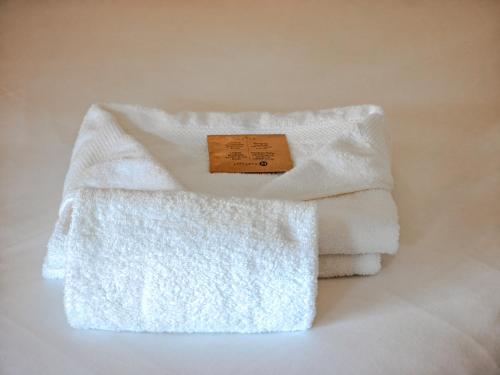 two white towels with a sign on top of them at Les Rizières in Saintes-Maries-de-la-Mer