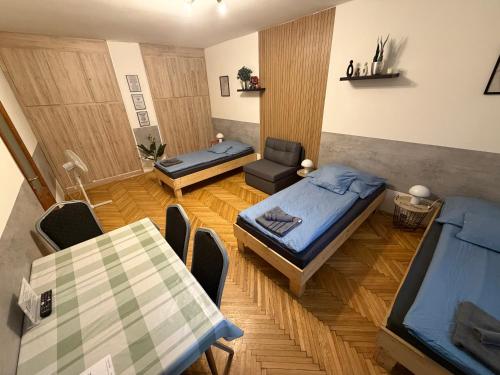 a small room with two beds and a table at Carlos Apartman Kecskemét in Kecskemét
