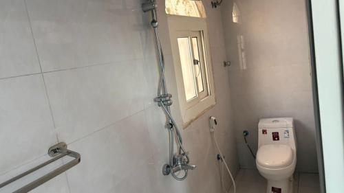 a bathroom with a toilet and a window at الصفا in Jeddah