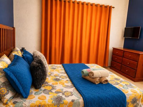 a bedroom with a bed with an orange curtain at Sol Dominicus 1 Apartamento con Cocina Solo Adultos in La Laguna