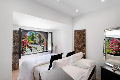 a bedroom with a bed and a window with flowers at Villa Belle Epoque Saint-Raphaël in Saint-Raphaël