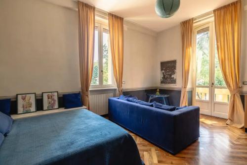 a bedroom with a blue bed and a couch at Maison Martina in Rivoli