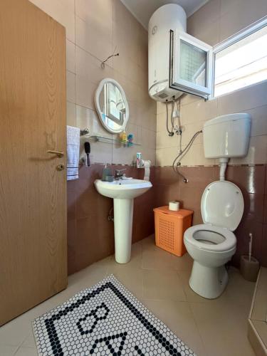 a bathroom with a toilet and a sink and a mirror at The Lakehouse in Krnjice