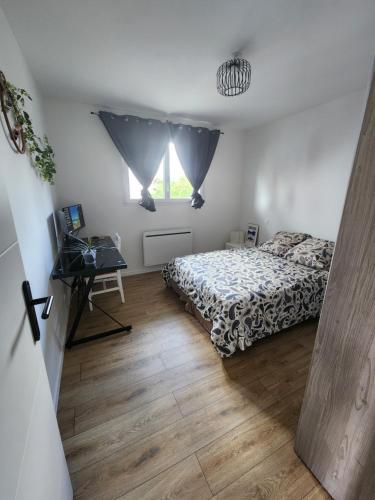 a bedroom with a bed and a desk and a window at Chambre chez Rena in Saint-Jean-de-Luz