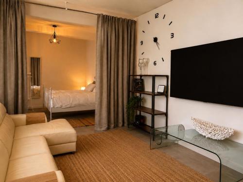 a living room with a couch and a flat screen tv at Atlantic View Loft - Spa & Sunset in La Orotava