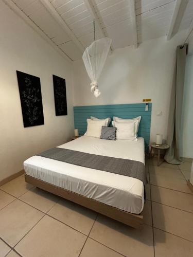 a bedroom with a large bed with a blue headboard at Petit Havre Bleu in Le Gosier