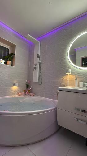 a white bathroom with a tub and a mirror at Ocean Soul Apartment in Santa Cruz de Tenerife