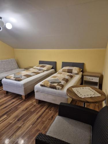 a room with three beds and a table at Apartmán Ružiná in Ružiná