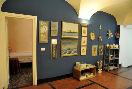 una habitación con una pared azul con fotos en ella en Erasmo Rooms & Breakfast, en Finale Ligure