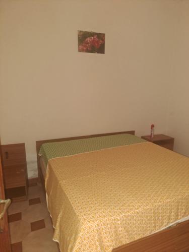 a bedroom with a bed with a yellow comforter at Villette Pepe in Coccorino