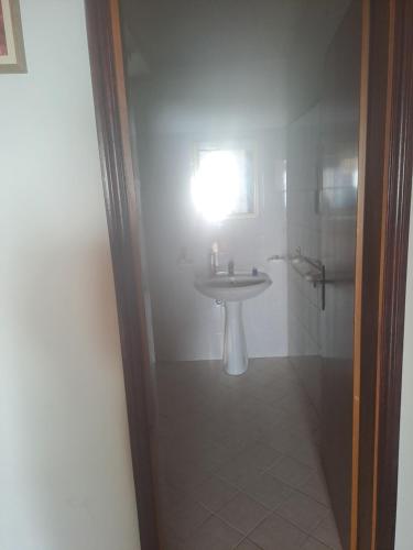 a bathroom with a sink and a light on the wall at Villette Pepe in Coccorino