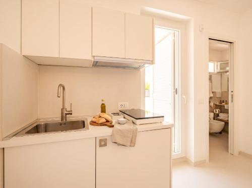a kitchen with white cabinets and a sink at Chiantera in Polignano a Mare