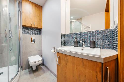 a bathroom with a sink and a toilet and a shower at Jantar Park in Jantar
