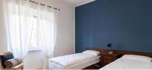 a bedroom with two beds and a window at Arturs B&B Roveredo in Roveredo