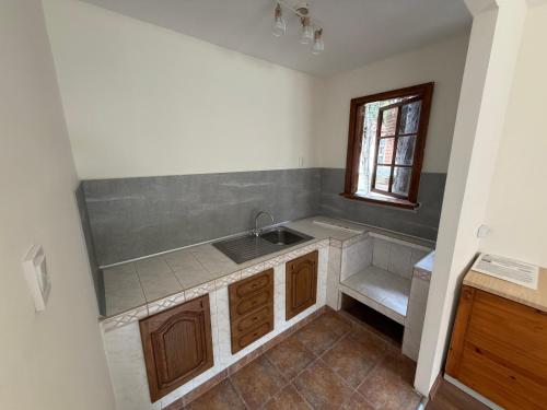 an empty kitchen with a sink and a window at Orpheus Hotel in Varna City
