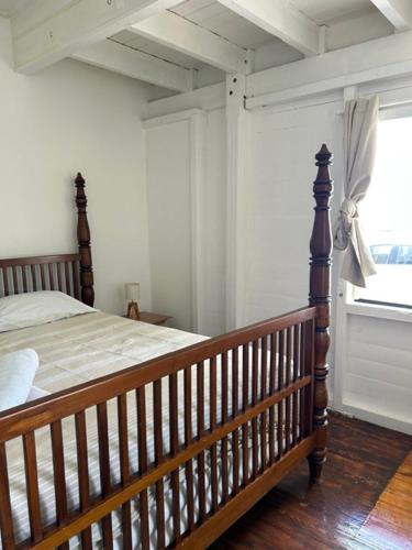 a bedroom with a wooden bed and a window at Casa Papaya in Marigot