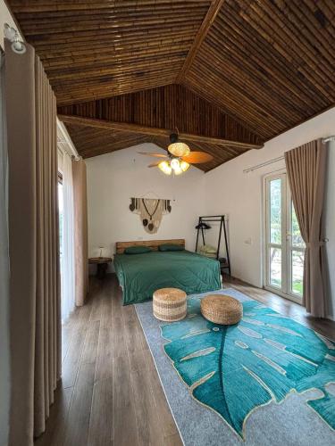 a bedroom with a green bed and a rug at Chậm Viên Le Jardin in Thanh Lâm